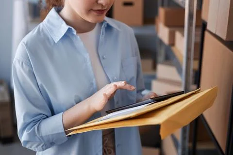Close-up of young woman in casualwear using tablet in warehouse Stock Photos