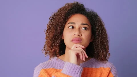 Close-up of young woman choosing, making decision looking at camera on lilac Stock Footage 294989455