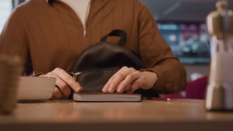 Close up of young woman closing open notebook on wooden table with black Stock Footage 344868646