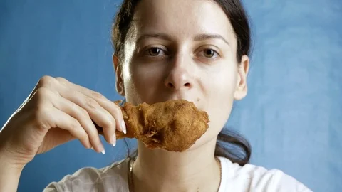 Close-up, young woman eats, fast food, chicken nuggets, wings and chicken leg Stock Footage 127024687
