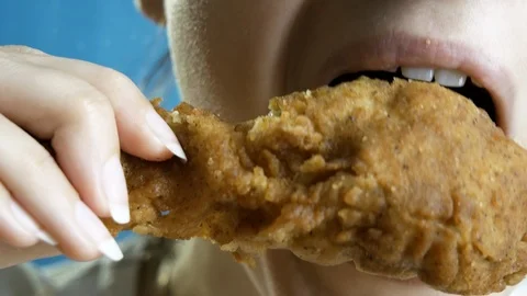 Close-up, young woman eats, fast food, chicken nuggets, wings and chicken leg Stock Footage 127024830