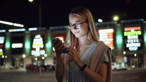 Close up young woman with glasses using phone smiling standing on street town Stock Footage 136846901