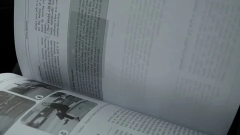 Close up young woman hand turning flipping book pages reading in a car Stock Footage