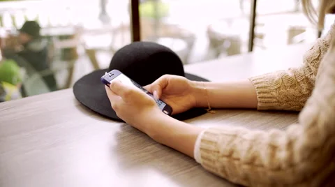 Close up of young woman hands typing message on phone in cafe Stock Footage 68926366
