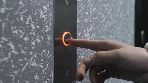 Close-up of a young woman pressing the elevator call button.The color of the Stock Footage 233809575