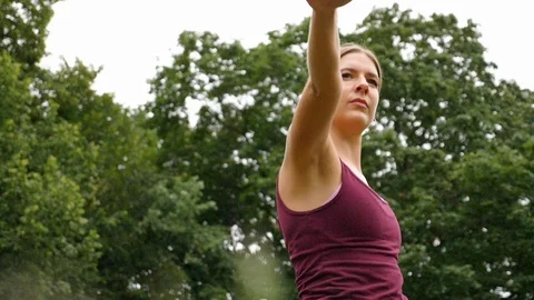Close-up of young woman stretching while doing yoga in park in slow motion Video stock 114873465