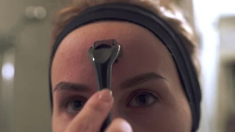 Close up young woman using a derma roller for micro needling therapy face. Stock Footage 78500002