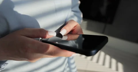 Close-up young woman using smartphone in living room at home. Girl using texting Stock Footage 335884884