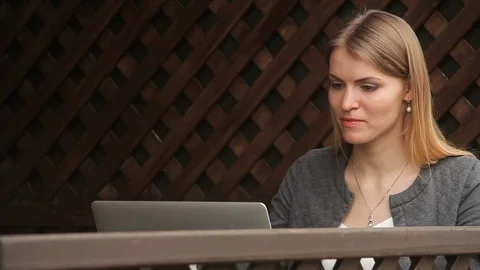 Close up of a Young Woman working with a laptop and drinking coffee on the terra Stock Footage 114109341