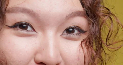 Close-up of a young woman's eyes, featuring detailed view of eyelashes and skin Stock Footage 346650164