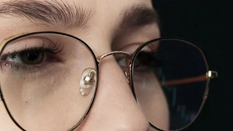 Close up of young woman's face and computer graphing display with glasses. Stock Footage 190929338