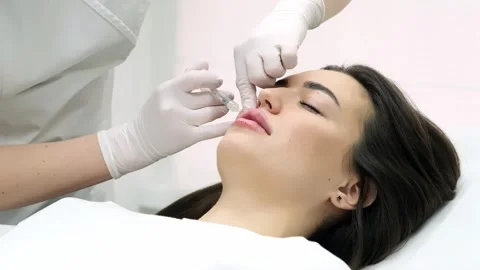 Close-up of a young woman's face undergoing lip augmentation procedure 動画素材 267752809