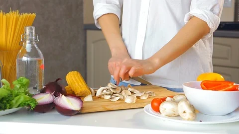 Close-up of a young woman's hand cutting vegetables Stockbeeldmateriaal 106396863