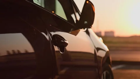 Close-up of young womans hand opens door of red car at sunset. Cinematic slow Stockbeeldmateriaal 220075211