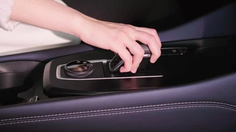 Close-up of a young woman's hands changing gear in an electric car. Stock Footage 274982364