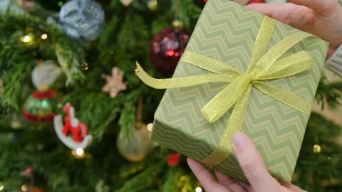 Close-up of young woman's hands holding New Year's gift box with golden ribbon Stock Footage 218606563