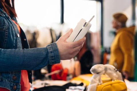 Close-up of a young woman's hands looking at a handbag to buy it, in a fashion Stock Photos