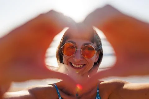 Close-up of a young woman's hands making a heart shape. Portrait of a beautif Stock Photos