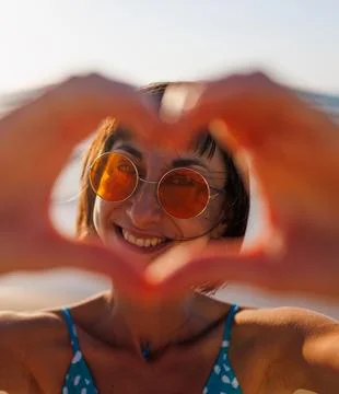 Close-up of a young woman's hands making a heart shape. Portrait of a beautif Stock Photos