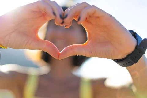 Close-up of young woman's hands making heart shape with fingers. Portrait o.. Stock Photos