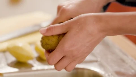 Close-up of a  young woman's hands peeling potatoes Stock Footage 120711367