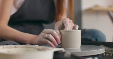 Close-up of young woman's hands in pottery studio using pottery wheel, handmade Stock Footage 155358428