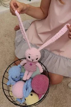 Close-up of a young woman's hands pulling a naughty pink hare from a basket by Stock Photos