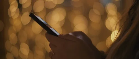 Close up of a young woman's hands scrolling over social media on her phone Stock Footage 123442783