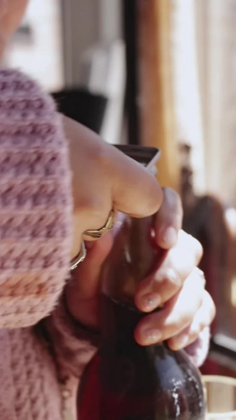 Close-up of a young woman's hands trying to open a glass bottle Stock Footage 314912797