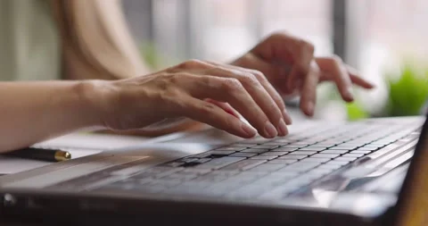 Close up of young woman's hands typing on laptop in cafe.Girl sitting near Stock Footage 159416463