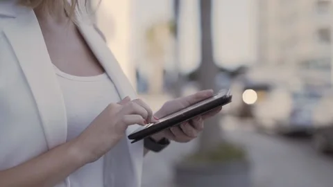 Close-up of young woman's hands using tablet in city Video stock 132037539