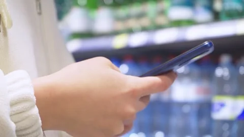 Close-up of a young woman's hands using a smartphone and shopping in a Stock Footage 275593904