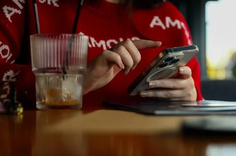 Close up of a young woman's hands using a smartphone in a cafe, lifestyle a.. Stock Photos