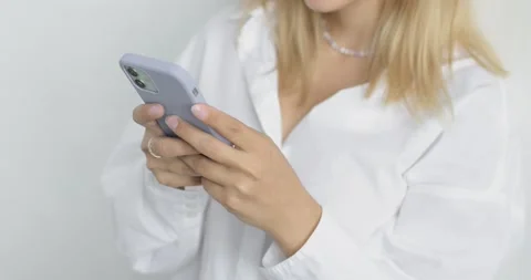 Close-up of a young woman's hands in white shirt with blond hair, on a white Stock Footage 159811285