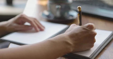 Close up of young woman's hands writing personal notes in ring-bound notebook Stock-Footage 158958152