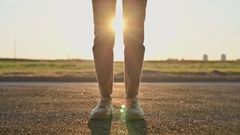 Close-up of young womans legs in light beige jeans, white sneakers stand in Stockbeeldmateriaal 197801688