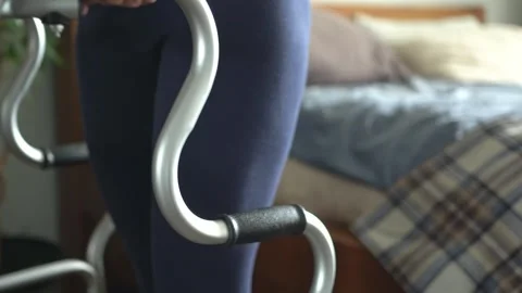 A close-up of a young woman's legs slowly walking with a walker at home. 스톡 동영상 340951580
