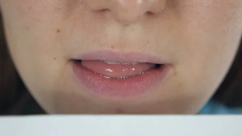 Close-up of young woman's lips licking white envelope for sending Stock Footage 144387904