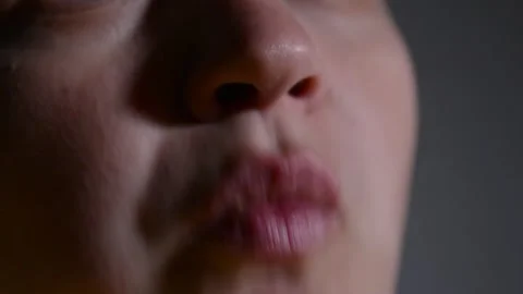 Close up of a young woman's lips as she eats corn rings. Video stock 337069368