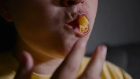 Close up of a young woman's lips as she eats corn rings. 스톡 동영상 337069390