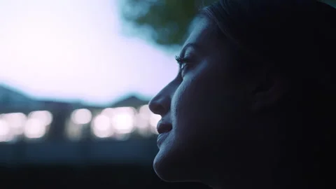 Close up of young womans profile with evening city lights in the background Stock Footage 203587518