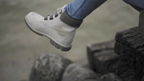 Close Up Of Young Women's Hiking Boot Dangling Over A Lake Stock Footage 147130366