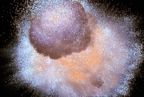 Close-up zero gravity orange and gold starburst exploding twice, with debris Vídeos de archivo 86915443