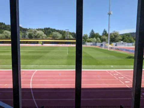 Closed athletic stadium viewed through the metal fence Stock Photos
