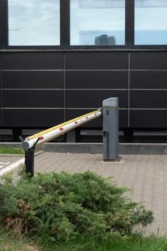 Closed automatic boom barrier gate controls vehicle access at office parking Stock Photos