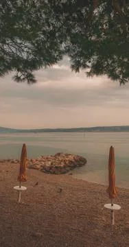 Closed beach parasol at empty seaside coast in Crikvenica, Croatia Stock Photos