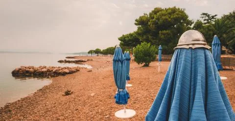 Closed beach parasol at empty seaside coast in Crikvenica, Croatia Foto stock