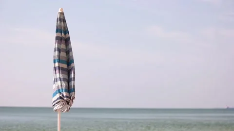 Closed beach umbrella waving on the beach wind. Video stock 246742884