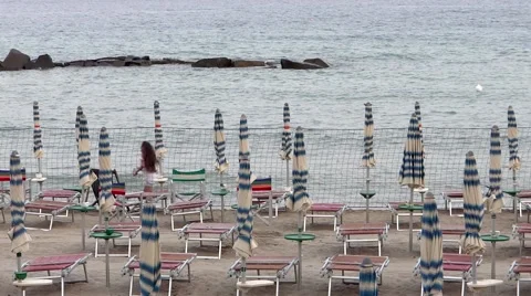 Closed beach umbrellas and running girl Video stock 41380367