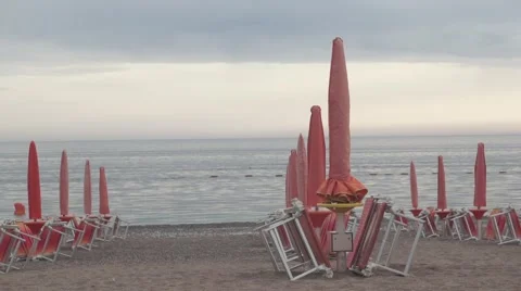 Closed beach umbrellas on the beach in the evening Video stock 50312820
